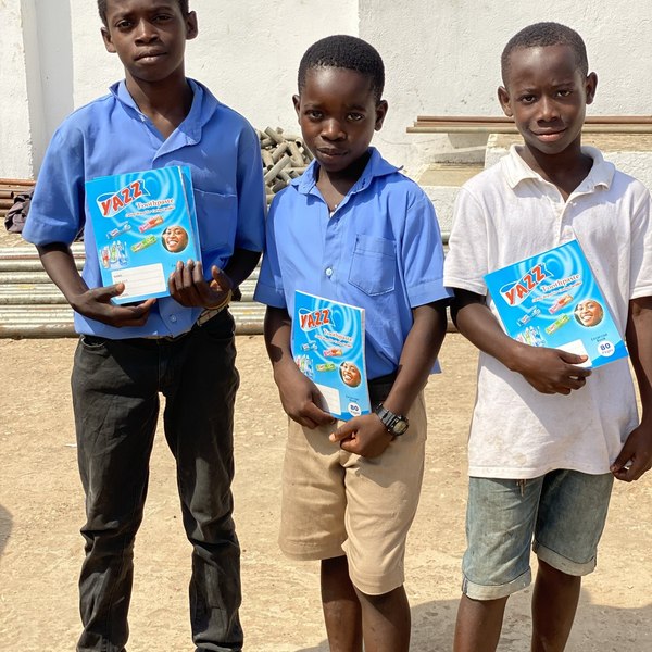 Three young dreamers proudly holding their new notebooks